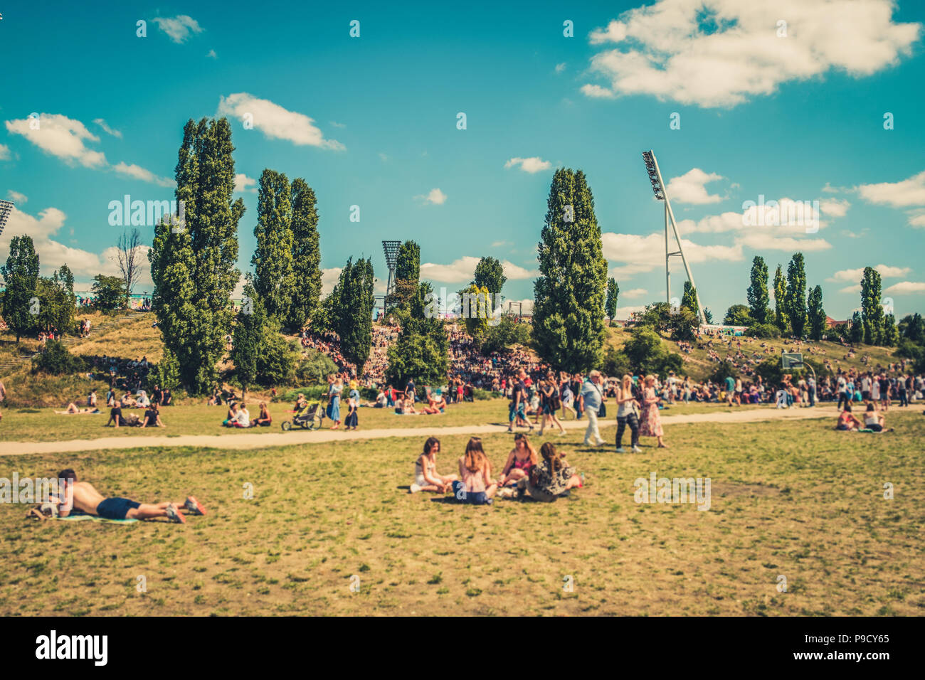 Cityscape blur concetto - Persone godendo di giorno d'estate e di sole sul prato in affollato parco (Mauerpark) in Berlin City - Foto Stock