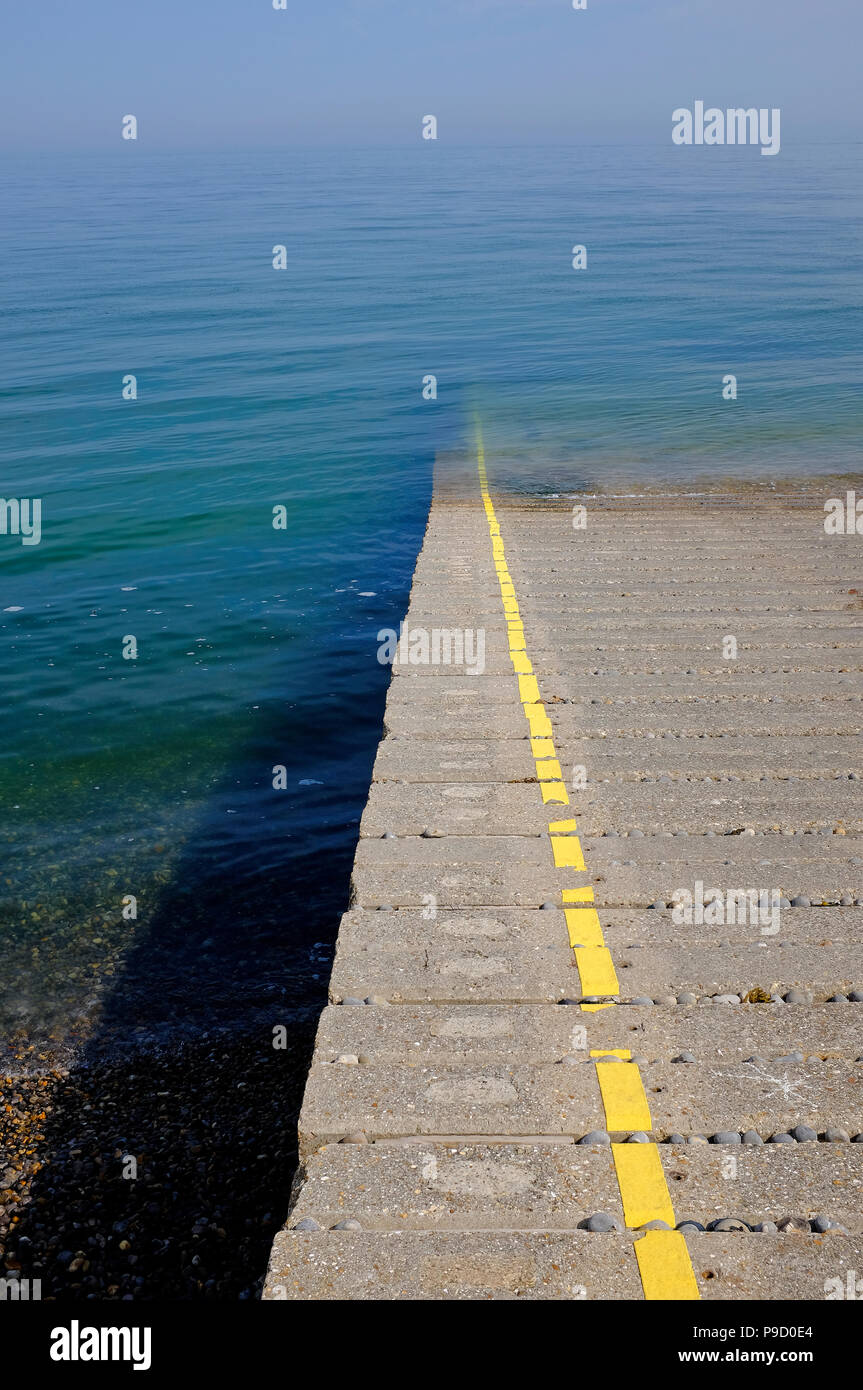 Verniciato giallo linea retta su calcestruzzo scalo, sheringham, North Norfolk, Inghilterra Foto Stock