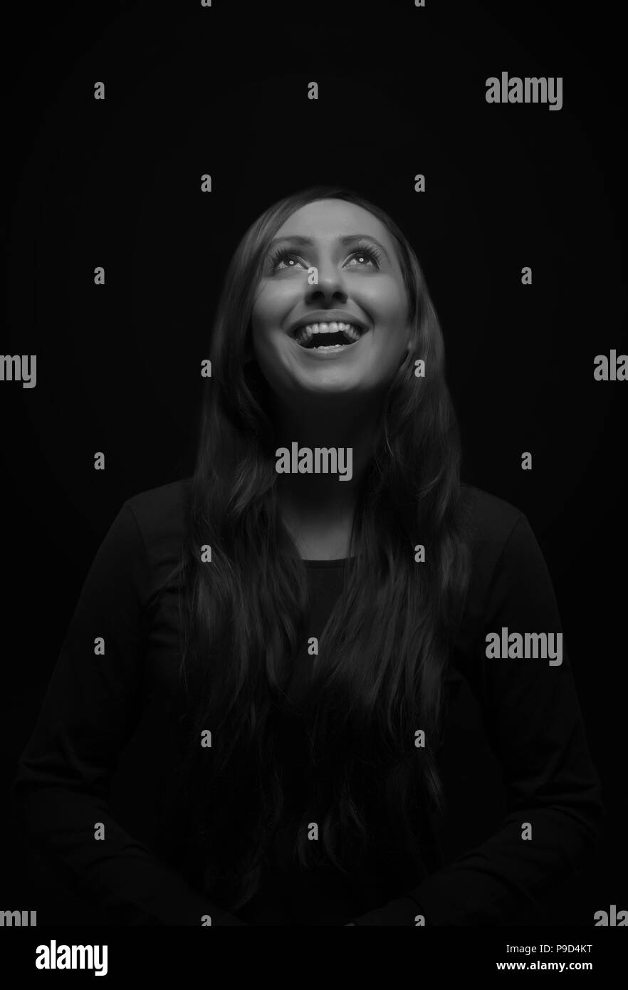 Ritratto di sorridente giovane donna che guarda verso l'alto Foto Stock