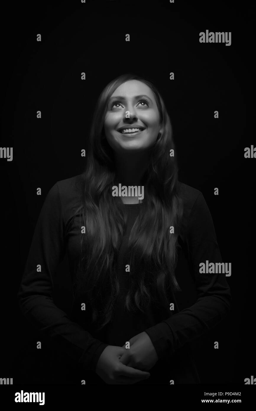 Ritratto di sorridente giovane donna che guarda verso l'alto Foto Stock