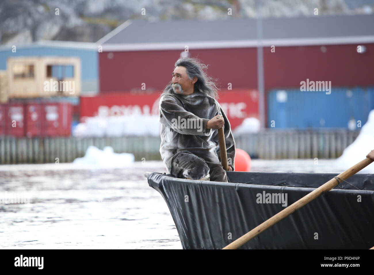 La Groenlandia, Nanortalik Inuit maschio in abito tradizionale canoa Foto Stock