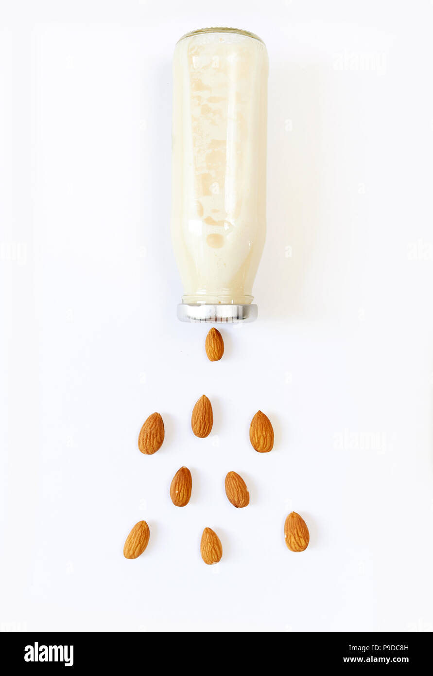 Latte di Mandorla e semi di mandorle su sfondo bianco, latte vegetale, il concetto di una corretta alimentazione cibo crudo vegan Foto Stock