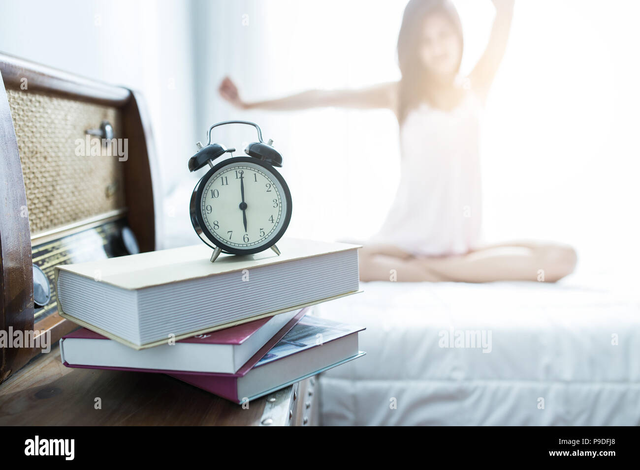 Giovane donna stretching sul letto dopo il risveglio al mattino, svegliarsi concept Foto Stock