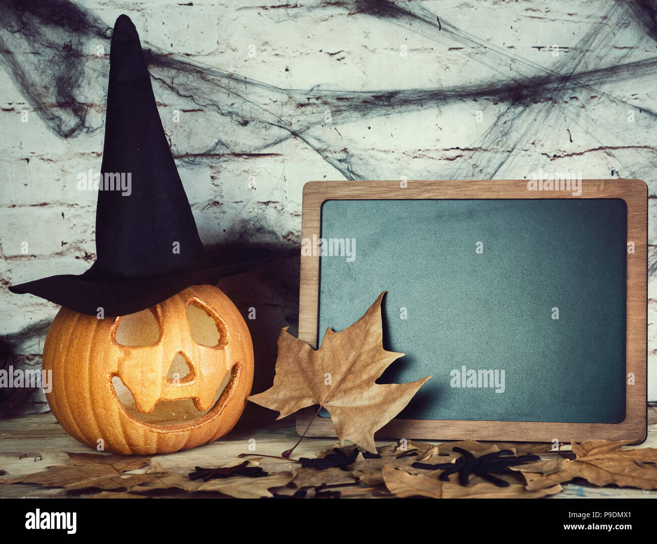 Zucca di Halloween e lavagna sul tavolo di legno Foto Stock