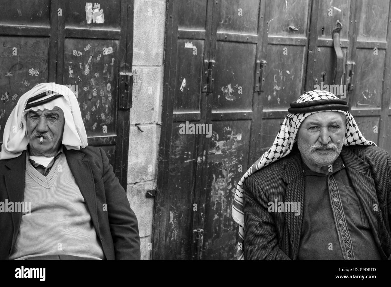 Due uomini palestinesi sono seduti avente una chat un zigarettes nella parte vecchia della città di Hebron og che recano insediamenti illegali dalle truppe Isra Foto Stock
