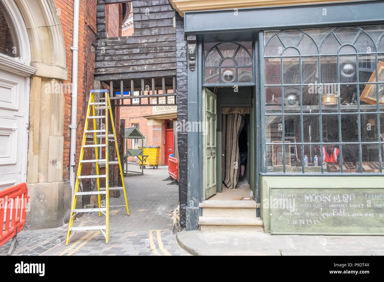 Un set cinematografico, impostazione e costruzione di falsi fronti per negozi e windows in Hull Foto Stock