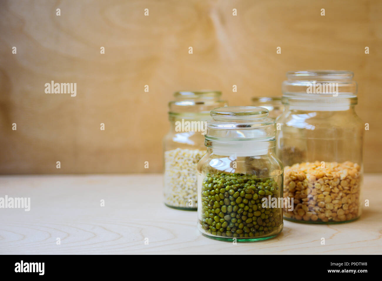 Mung bean in un barattolo di vetro nei pressi di piselli secchi, di riso e di orzo perlato Foto Stock