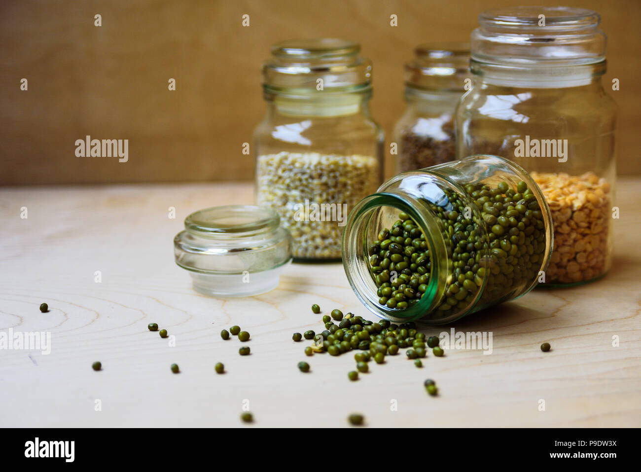 Mung bean in un barattolo di vetro nei pressi di piselli secchi, di riso e di orzo perlato Foto Stock