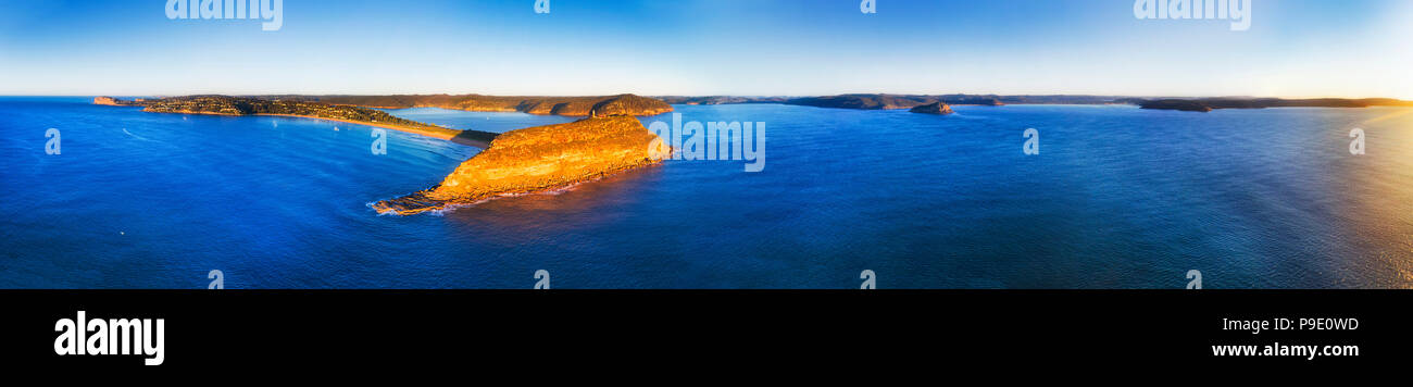 Palm Beach e testa Barrenjoye su Sydney Nord spiagge costa all'entrata del fiume Hawkesbury presso sunrise in ultra wide seascape panorama. Foto Stock