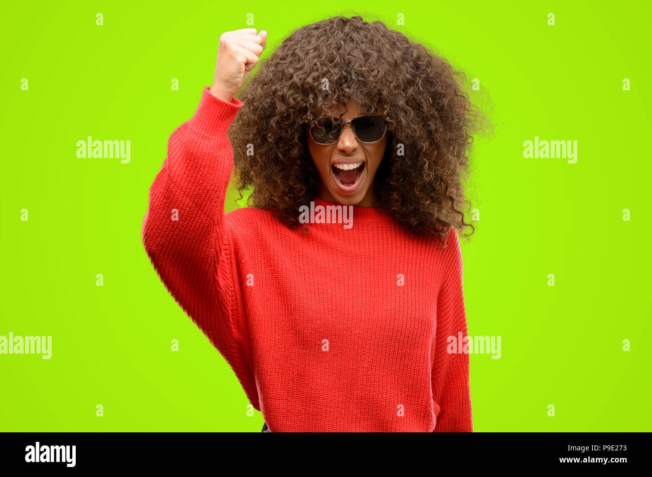 African American donna che indossa gli occhiali da sole irritato e arrabbiato esprimendo emozione negativa, arrabbiato con qualcuno Foto Stock