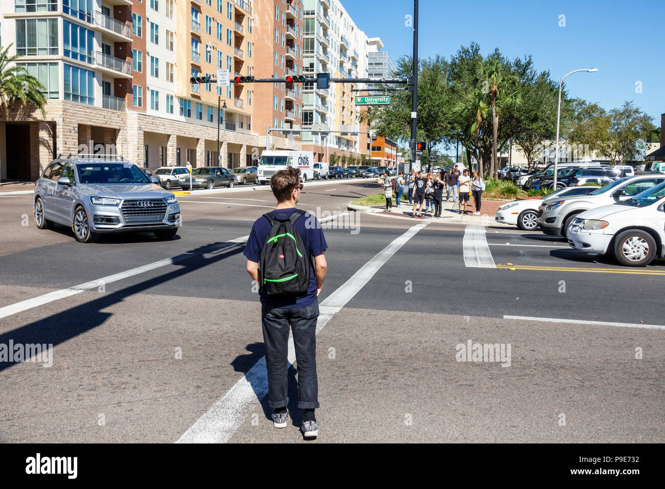 Gainesville Florida, University Avenue, incrocio stradale strada studenti che attraversa uomo uomo zaino maschio Foto Stock