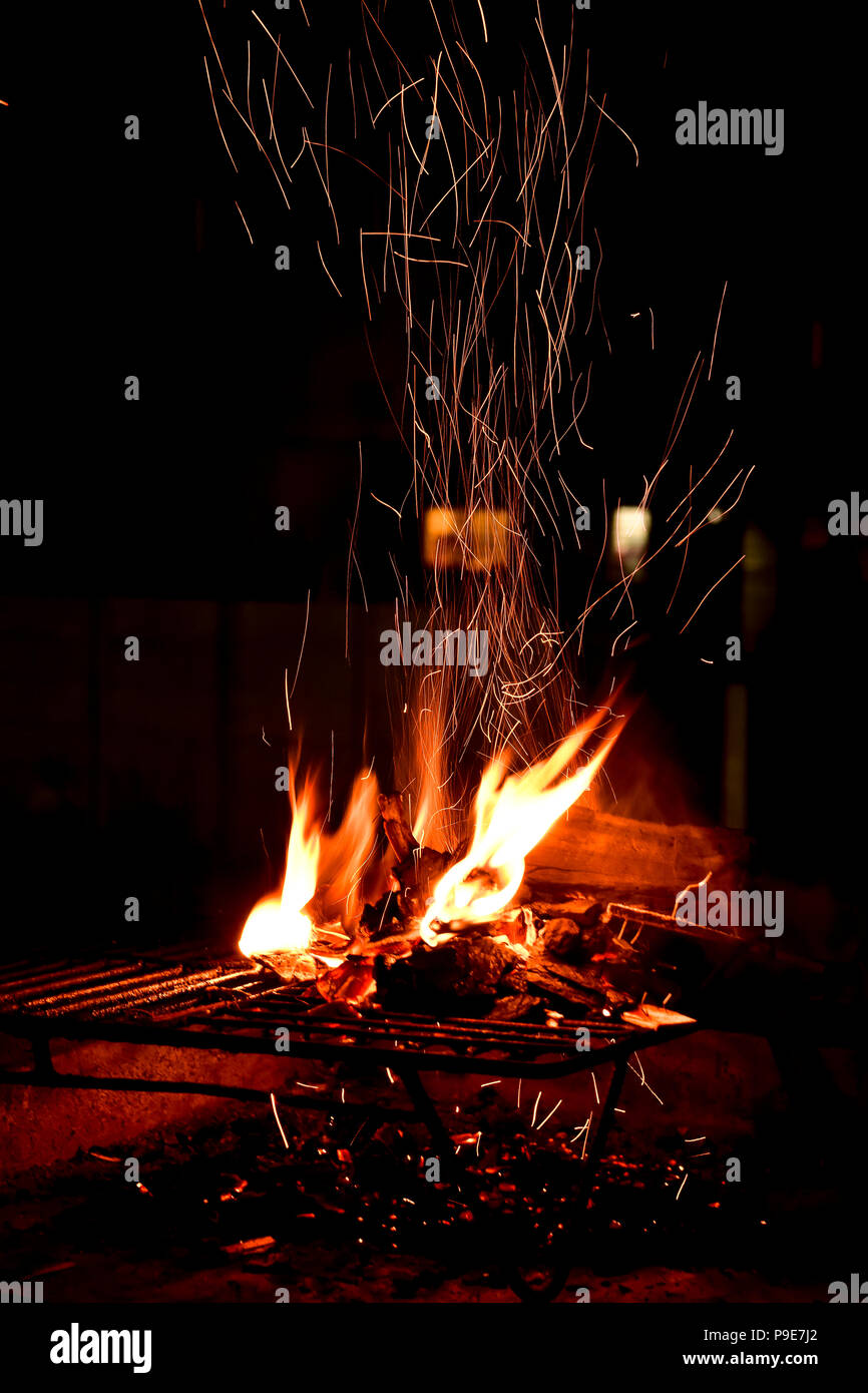Il posto del fuoco su una notte estiva che mostra i dettagli delle scintille e fiamme risplende nelle tenebre della notte Foto Stock