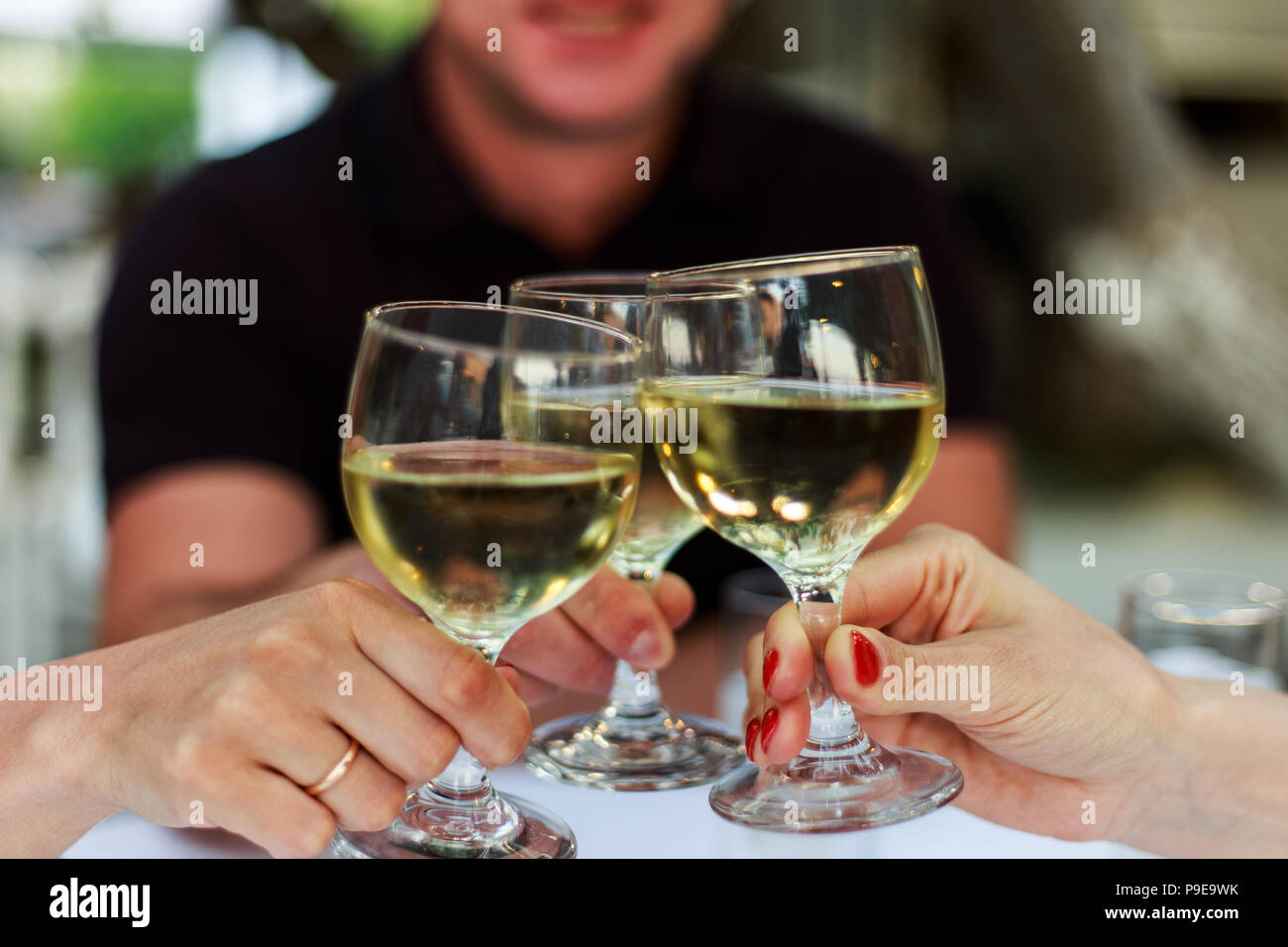 Versare il vino bianco in vetro contro il tavolo di legno Foto Stock