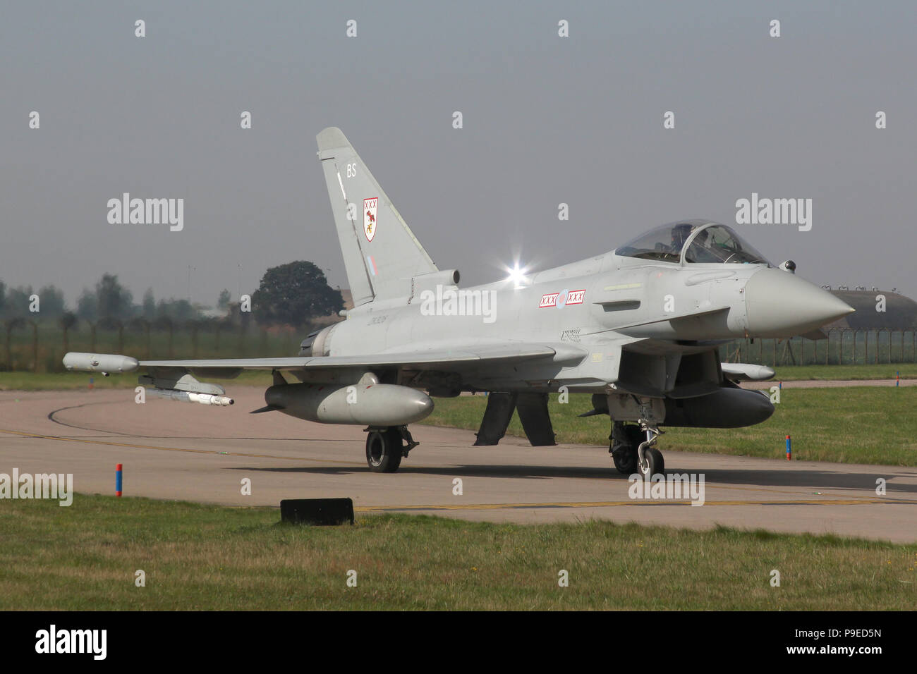 RAF Typhoon da 29 Squadron sulla pista di rullaggio del Sud a RAF Coningsby, Lincolnshire. Nota superiore luce stroboscopica. Foto Stock