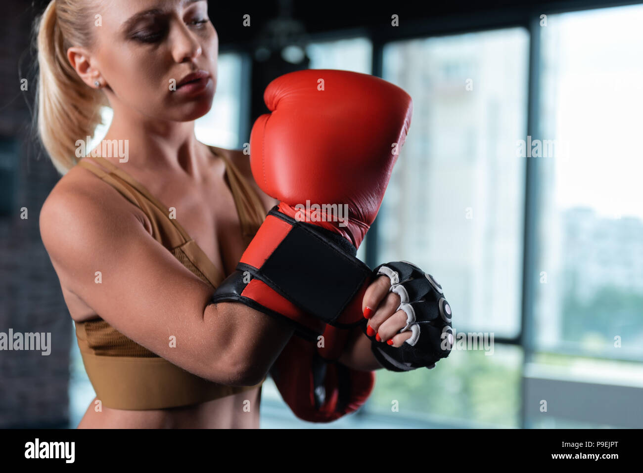 Close up di colore rosso brillante boxe indossando guanti da boxer femmina Foto Stock