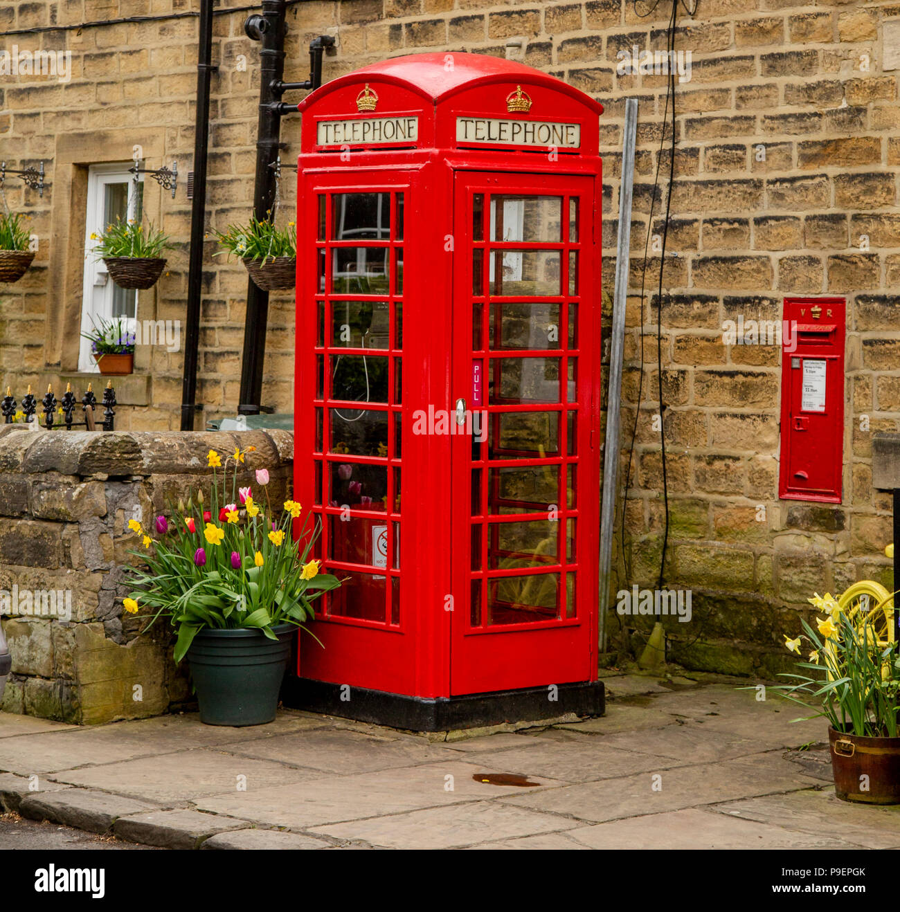 Un K6 telefono rosso scatola (UK) e la parete postbox in Esholt, West Yorkshire, Inghilterra. Foto Stock