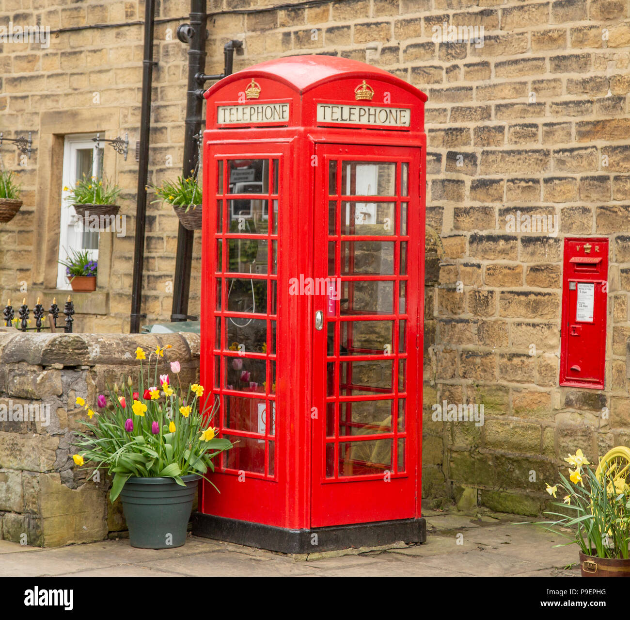 Un K6 telefono rosso scatola (UK) e la parete postbox in Esholt, West Yorkshire, Inghilterra. Foto Stock