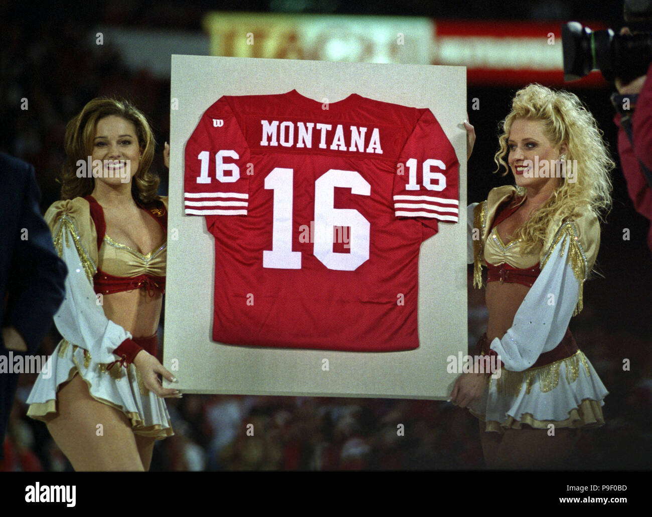 San Francisco, California, Stati Uniti d'America. 15 dic 1997. San Francisco 49ers vs. Denver Broncos al Candlestick Park Lunedì, 15 dicembre 1997. 49ers battere Broncos 34-17. Gold Rush cheerleader tenere Montana jersey durante le cerimonie per Joe Montana numero 16 jersey. Credito: Al di Golub/ZUMA filo/Alamy Live News Foto Stock