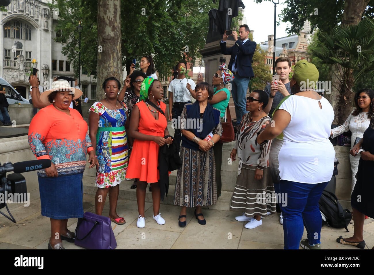 Londra REGNO UNITO. Il 18 luglio 2018. Persone provenienti da comunità sudafricana davanti alla statua di Nelson Mandela in Parlamento per celebrare il centenario dell ex presidente del Sud Africa che morì nel 2013 e che ha guidato la lotta contro il regime di apartheid Credito: amer ghazzal/Alamy Live News Foto Stock