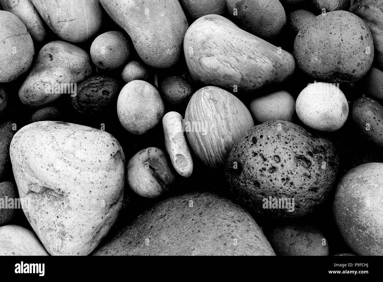 Ciotoli arrotondati / pietre / massi su una spiaggia nelle Azzorre in bianco e nero Foto Stock