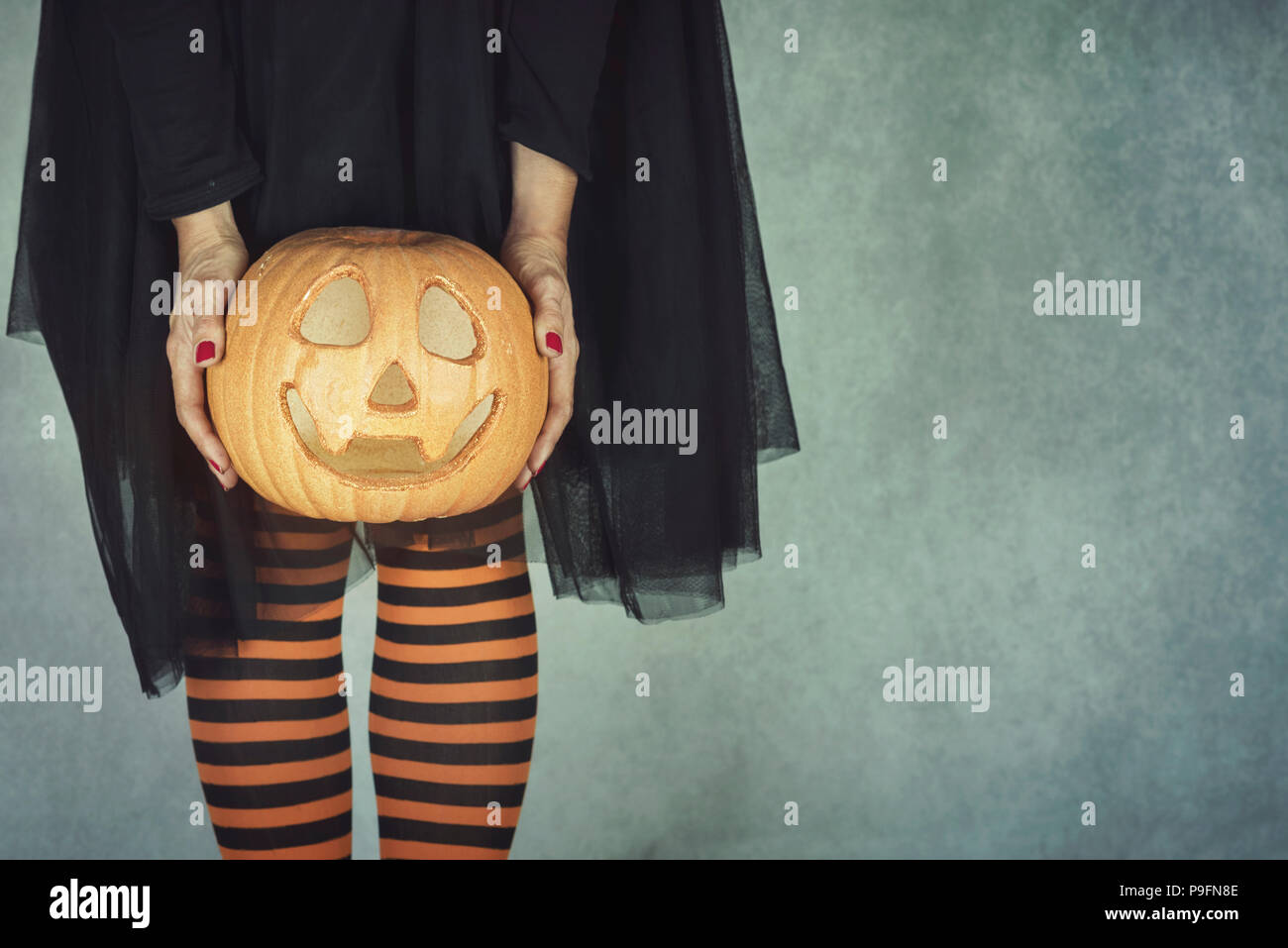 Close-up donna per le gambe con la zucca di Halloween Foto Stock