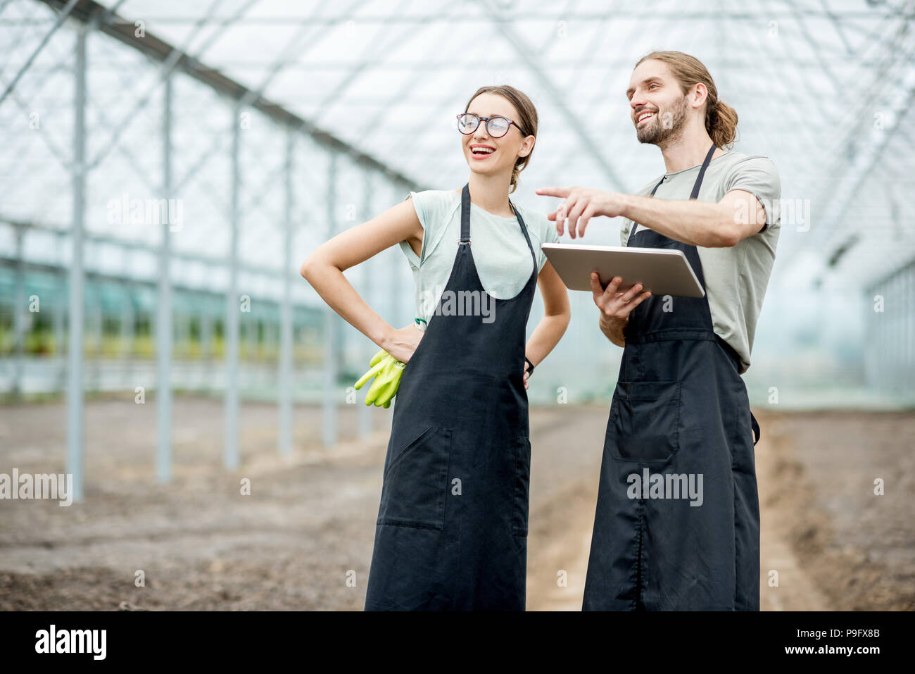 Gli agricoltori con la compressa in serra Foto Stock