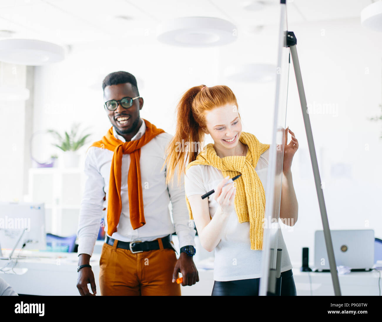 Due artisti disegno sulla lavagna a fogli mobili nel moderno studio Foto Stock