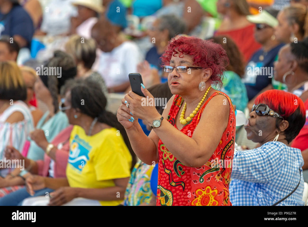 Detroit, Michigan - una donna usa il suo cellulare per film di azione durante il Senior amicizia Day, un evento che ha portato migliaia di cittadini anziani Foto Stock