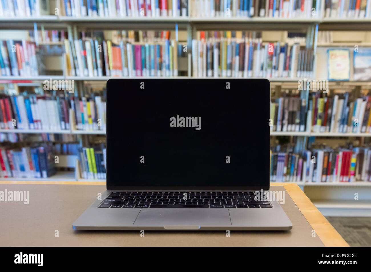 Schermo vuoto personal computer laptop sulla scrivania in biblioteca pubblica Foto Stock