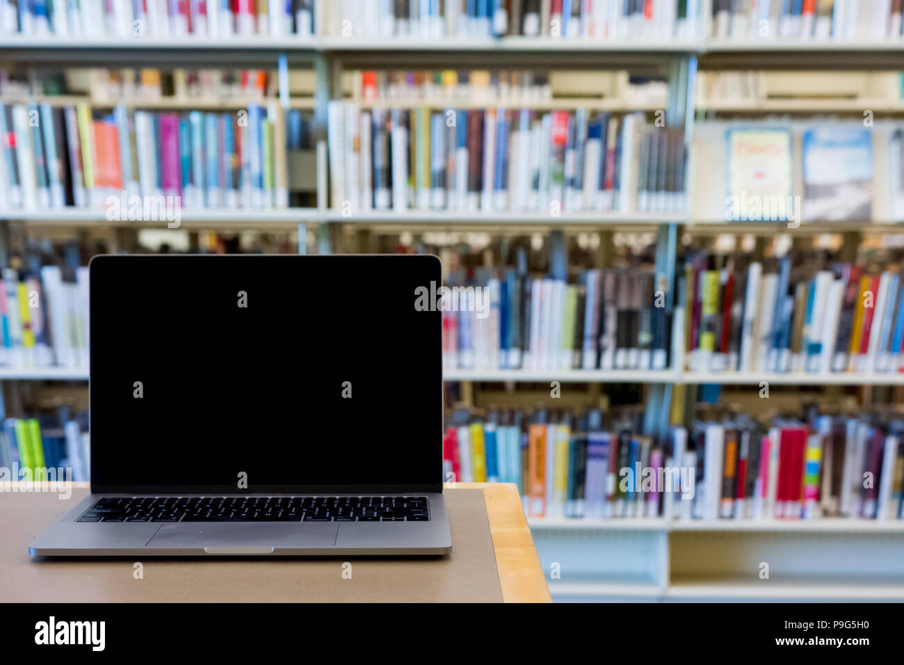 Schermo vuoto personal computer laptop sulla scrivania in biblioteca pubblica Foto Stock