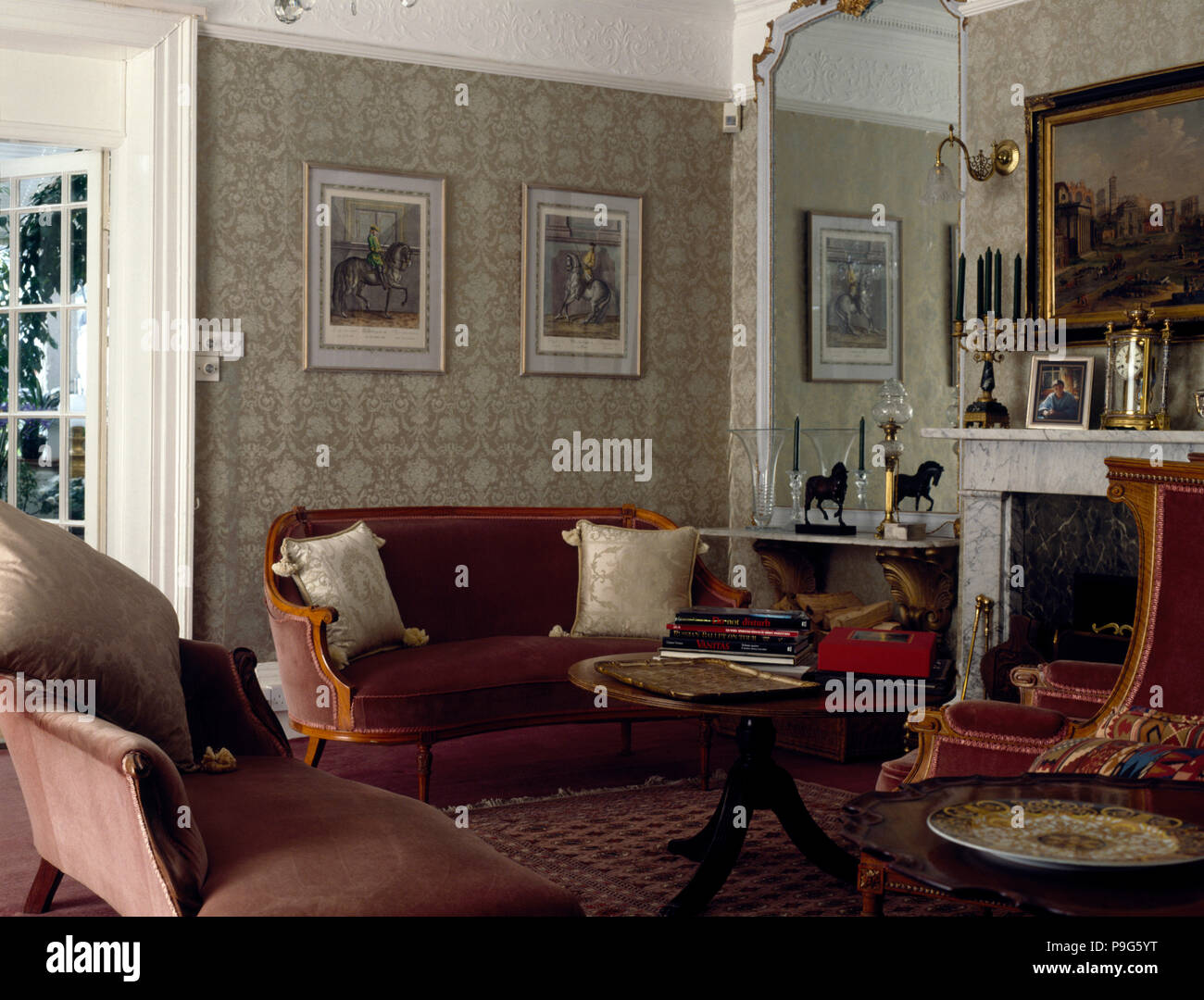Il velluto divani imbottiti in un vecchio salotto con un pallido sfondo grigio Foto Stock