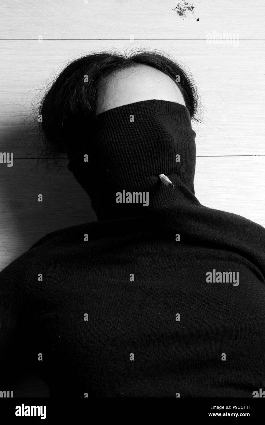 Una ragazza distesa sul pavimento con una sigaretta Foto Stock