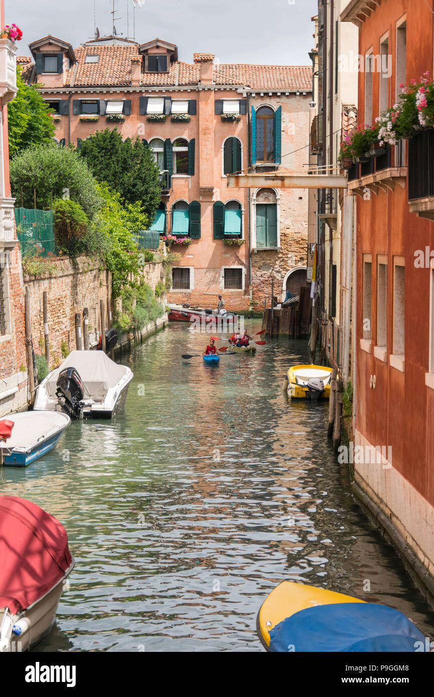 L'Europa, Italia, Veneto, Venezia. La gente visita Venezia in kayak, nuoto attraverso canali tra pittoreschi tenement case. Foto Stock