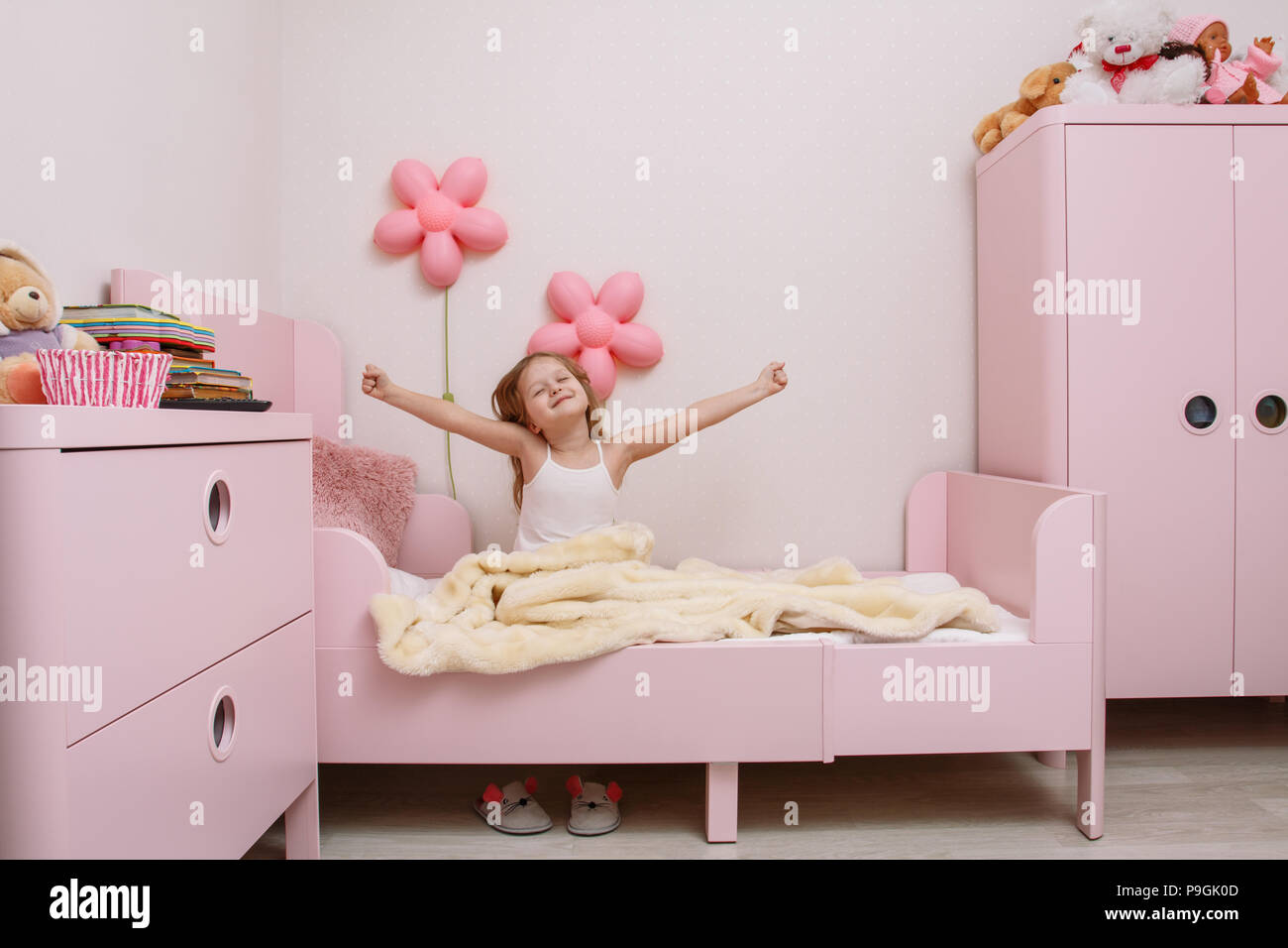 Piccola ragazza si sveglia al mattino in camera dei bambini Foto Stock