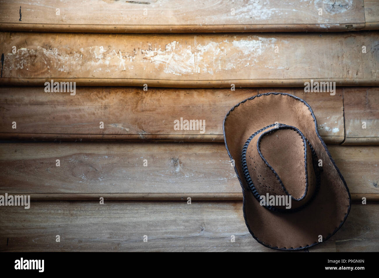 Un cappello da cowboy si blocca su grunge parete in legno Foto Stock
