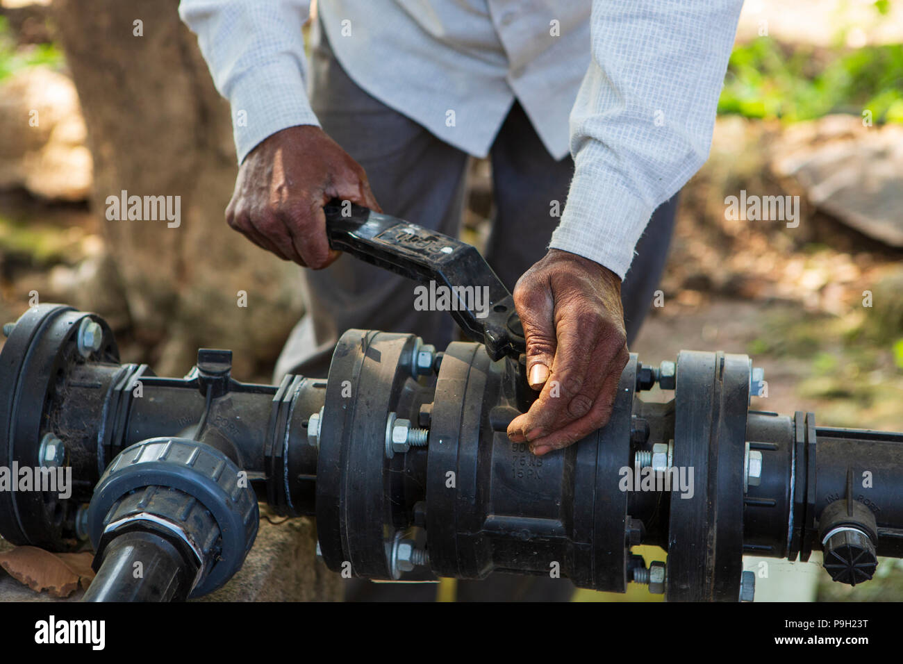 Un agricoltore si accende la pompa della sua nuova irrigazione di gocciolamento sistema che richiede molto meno tempo per l'acqua rispetto al precedente allagare irrigazione. Foto Stock