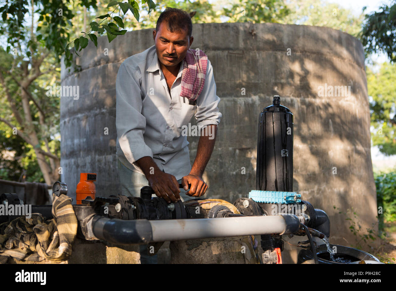 Un agricoltore si accende la pompa della sua nuova irrigazione di gocciolamento sistema che richiede molto meno tempo per l'acqua rispetto al precedente allagare irrigazione. Foto Stock