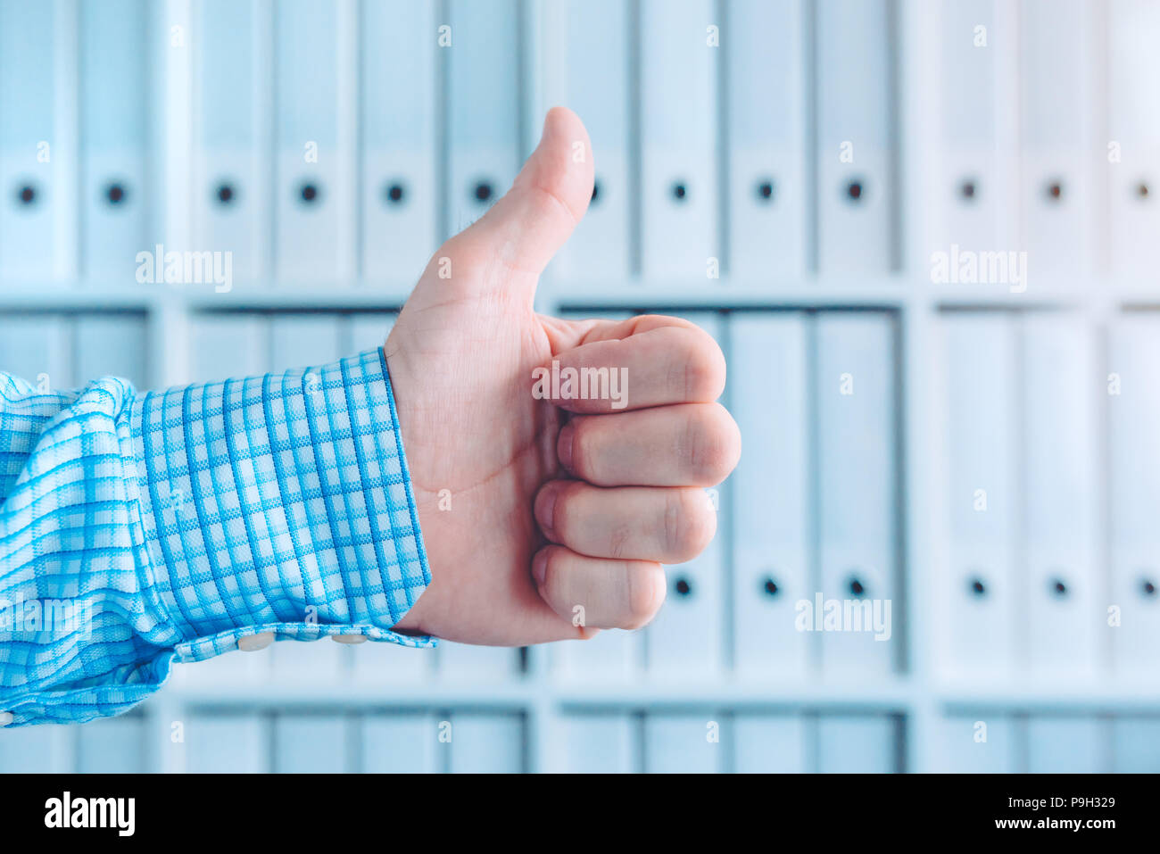 Contabile e commercialista gesticolando pollice in alto per il riconoscimento e la convalida Foto Stock