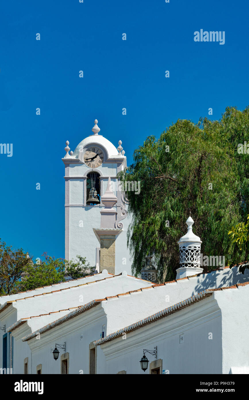 Un ornato di camino e la chiesa di São Lourenço, Almancil, Algarve. Foto Stock