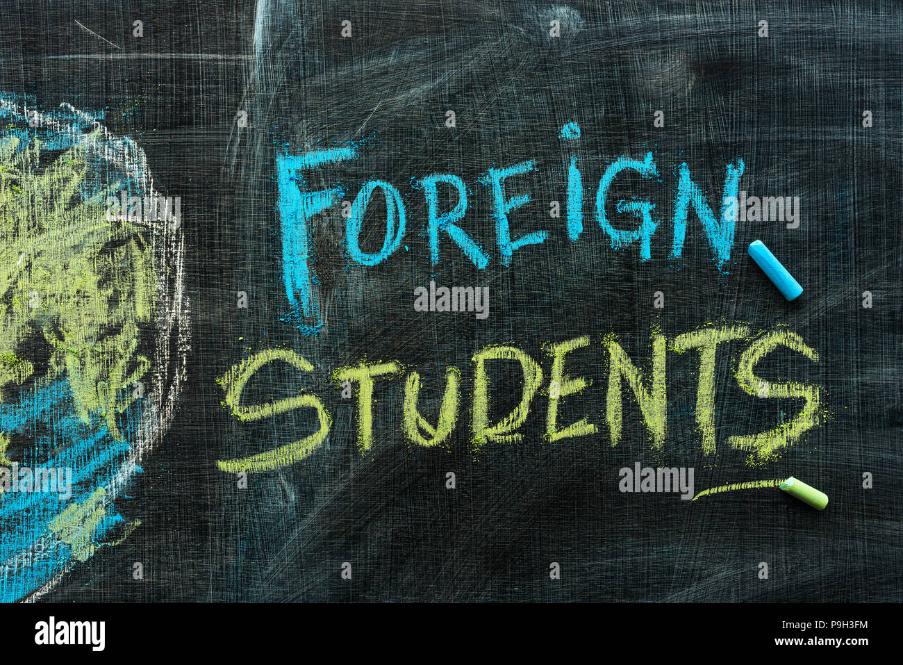 Gli studenti stranieri di scambio il concetto di programma con il testo scritto a mano in gesso sulla lavagna della scuola Foto Stock