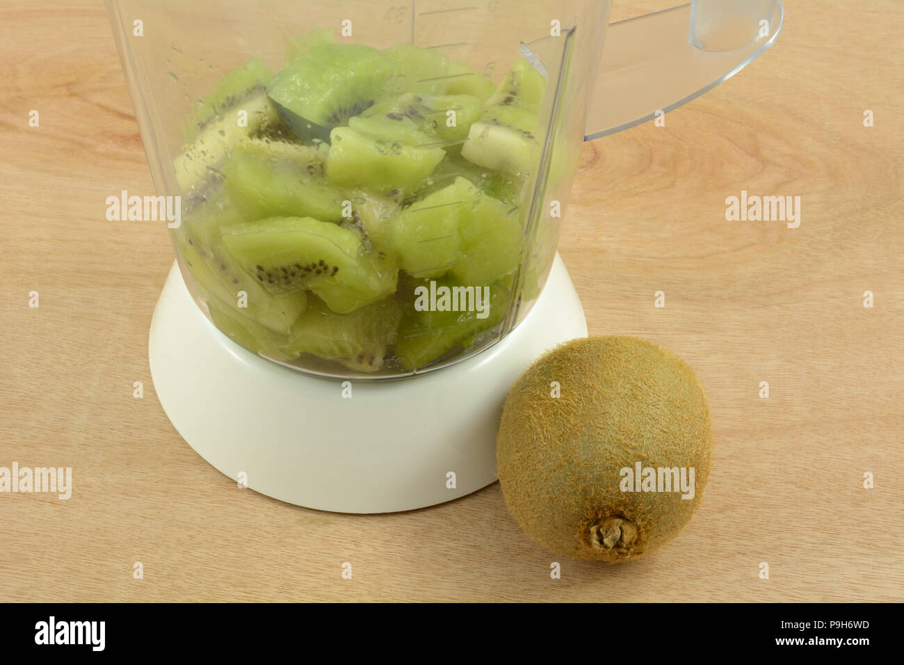 Il riempimento di Blender con kiwi fette di frutta per fare i frullati, daiquiri o popsicles Foto Stock
