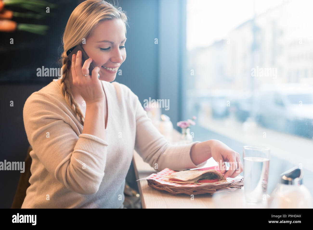 Donna che utilizza il suo telefono in treno dalla cabina per parlare con i tuoi amici Foto Stock