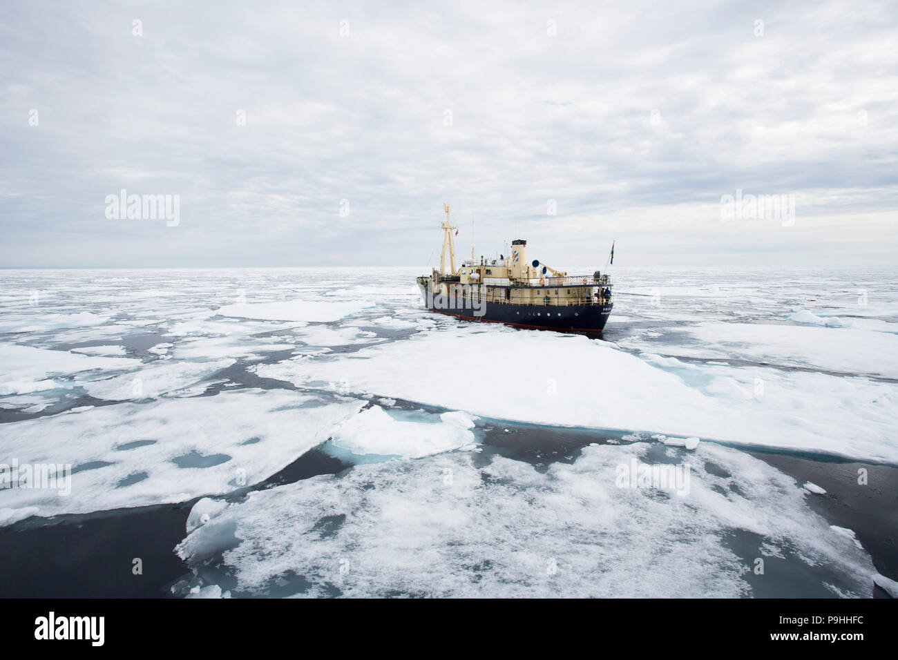 Piccola nave in mare di ghiaccio, Svalbard Foto Stock