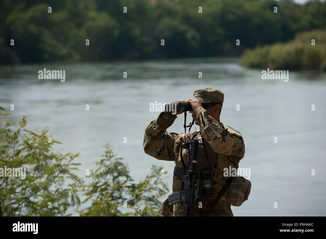 Un soldato dal Texas National Guard scansiona le rive del Fiume Rio Grande in Starr County, Texas Aprile 10 come parte della Federal call-fino al confine Texas-Mexico. I soldati chiamati a dovere al confine di supporto partner federale e servono principalmente a osservare e ruoli di relazione Foto Stock