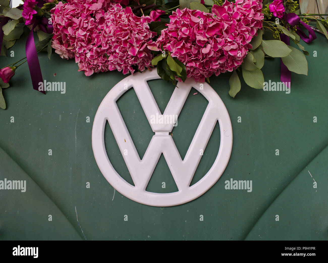 Bremen, Germania - Luglio 17th, 2018 - Close-up foto del fronte di un verde VW T3 van bianco con logo VW decorate con fiori di colore rosa Foto Stock