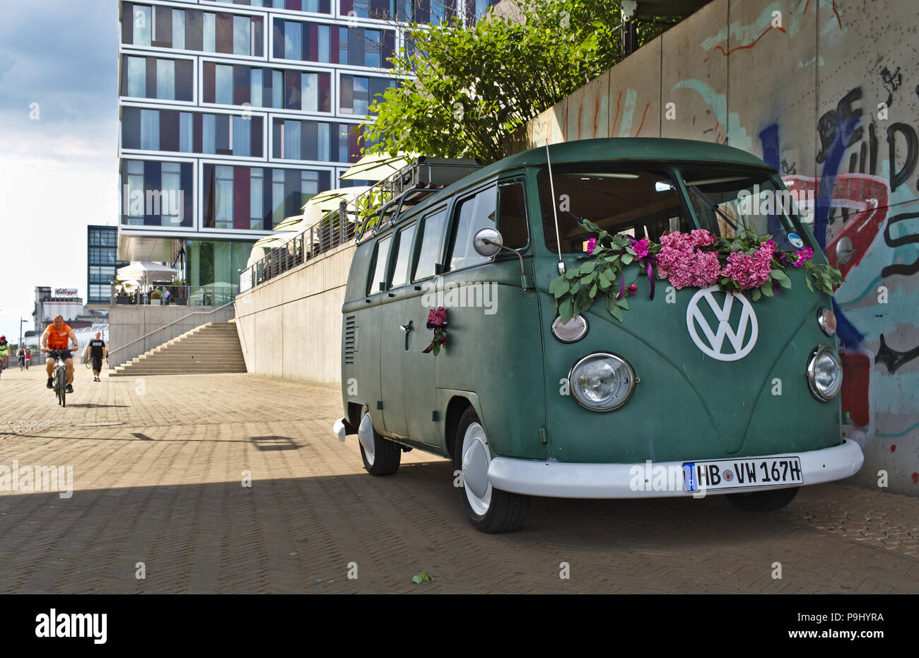 Bremen, Germania - Luglio 17th, 2018 - Verde VW T3 van con grandi bianchi logo VW con una moderna facciata in vetro e in background Foto Stock