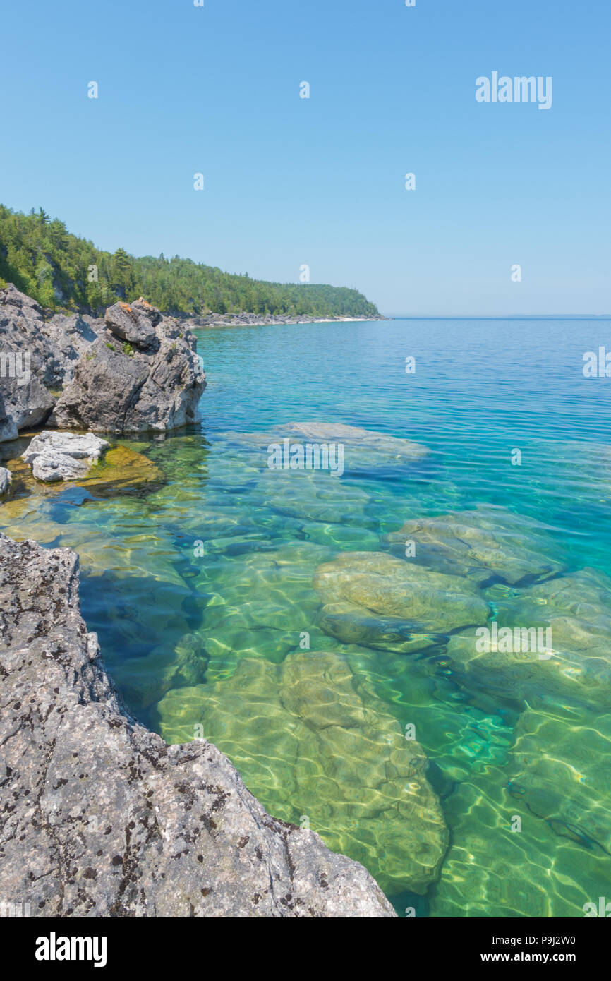 Chiaro luminoso verde acqua acqua sulla penisola di Bruce. Acqua cristallina mostra grandi rocce calcaree e cliff Foto Stock