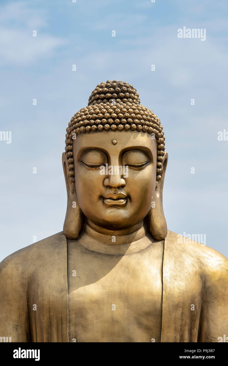 Golden statua del Buddha contro un cielo blu. Regno Unito Foto Stock