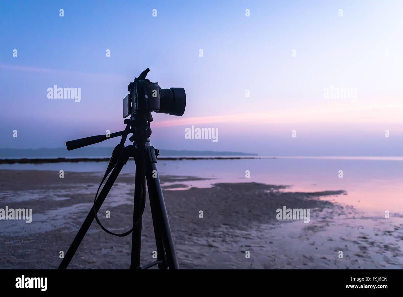 Reflex digitale professionale digitale fotocamera stand su treppiede fotografare mare, twilight sky e nube paesaggio. fotografo riprese video di sunrise nel Foto Stock