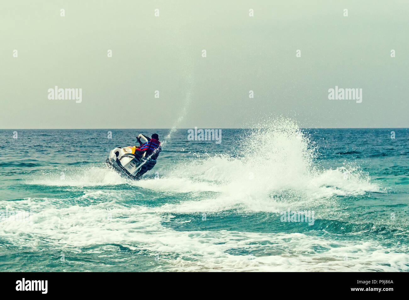 Giovane ragazzo la crociera sull'Oceano Atlantico su un jet ski. Attività ricreative in acqua di mare a La aquabike concorrenza. acqua entertainment in mare. estate Foto Stock